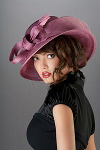 一位性感火辣的黑发女郎的肖像，卷发，戴着一顶漂亮的时尚帽子。