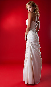 优雅的时尚模特金发女子穿着白色婚纱在红色领奖台上摆姿势-摄影棚拍摄
