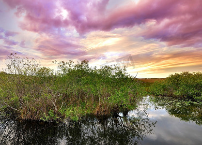 粉色河流摄影照片_热带河流上的七彩夕阳
