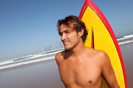 拉丁文摄影照片_海滩上英俊的冲浪者肖像