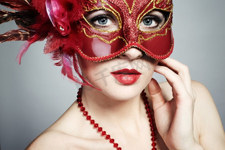 戴着红色神秘威尼斯面具的美丽年轻女子