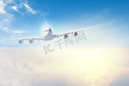 空中云层摄影照片_背景为云的飞机在空中飞行的图像