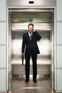 商人使用手机上电梯