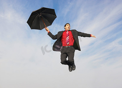 撑着雨伞的坠落商人