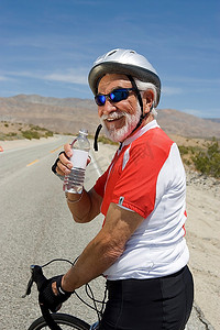 骑自行车喝水的老年男子