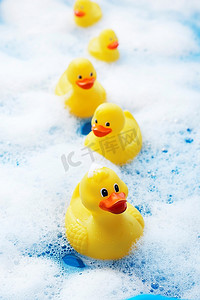 可爱鸭摄影照片_泡泡浴中的一排橡皮鸭