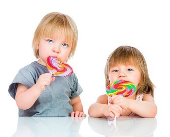 黏糊糊的摄影照片_婴儿在白色背景下吃黏糊糊的棒棒糖