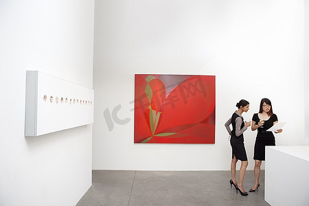 两个女人站在壁画旁边