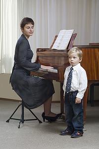 男童(3-4)在老师钢琴伴奏下唱歌