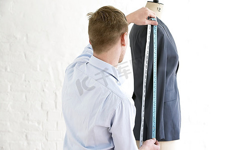 裁缝测量夹克袖子，后视图