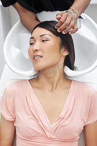 洗澡洗头摄影照片_一名亚洲女子在美容院洗头