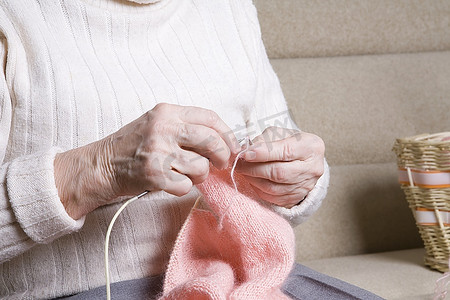 上了年纪的妇女坐着编织