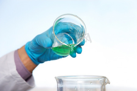 实验室技术人员浇注蓝绿色液体