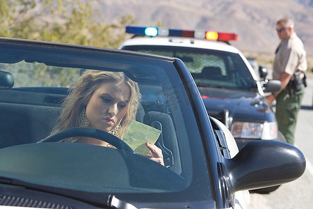 年轻女子在看超速罚单，背景是警察