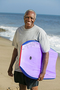 一位高龄男子手持冲浪板