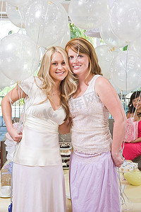 新娘和朋友站在一起，手持气球参加新娘送礼会