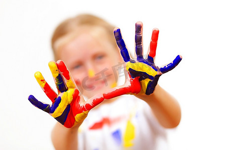 手画画摄影照片_小孩子的手被涂上了五颜六色的油漆，准备留下手印