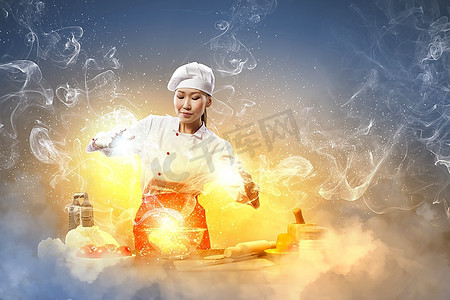 结界摄影照片_亚洲女性烹饪与魔术反对颜色背景