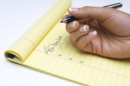 女人写下要做的任务清单，手部特写