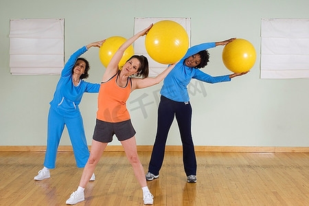 健身球摄影照片_女性在健身课上使用健身球