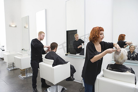 造型师在中性沙龙剪客户和敏锐的头发