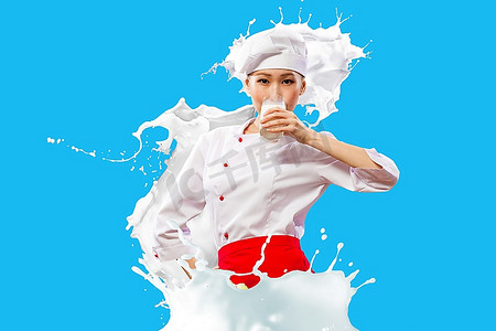 亚洲女厨师在喝牛奶的颜色背景下穿着红色围裙防止牛奶飞溅
