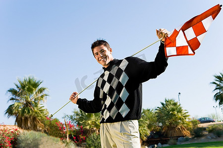 举着高尔夫球旗帜的年轻人