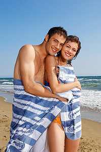 联系方式摄影照片_海滩上的年轻夫妇裹着毛巾，肖像
