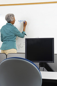 女教师写在白板在计算机教室