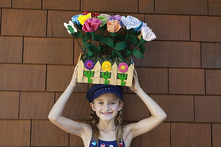 小女孩头上顶着木板箱里的人造花