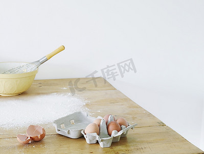 碗、鸡蛋和面粉散落在桌子上