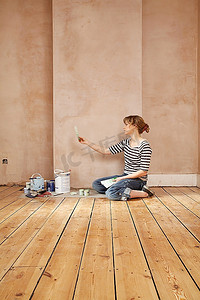 坐在地板上看油漆色板的女人