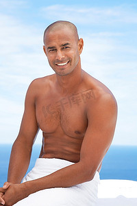 男子坐在毛巾圆腰微笑半身海洋背后