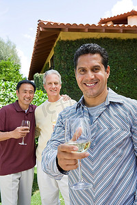 三个男性朋友在花园里喝酒，肖像