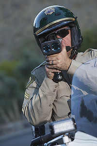 酒驾交警摄影照片_一名交警骑着摩托车看着车速表