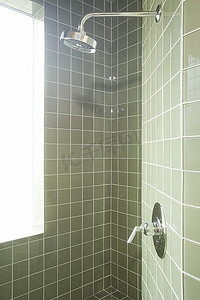 淋浴房内有柔和的绿色瓷砖