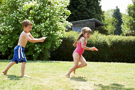 后院摄影照片_两个孩子玩着水枪