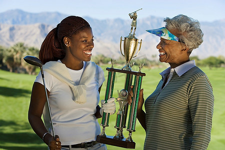 祖母和孙女手持高尔夫球奖杯