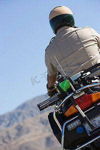 警察背影摄影照片_骑自行车的警察的背影