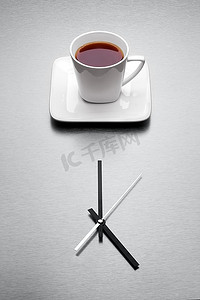 一只装满茶的白色杯子，摆着极简主义的时钟。