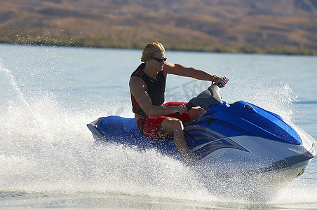 年轻人在湖上骑摩托艇水上摩托人物活动