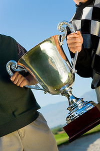 高尔夫球奖杯摄影照片_手持高尔夫球奖杯的男子