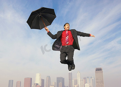 撑着雨伞摄影照片_撑着雨伞的坠落商人