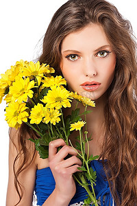 一位年轻清新的女子拿着一束黄花在镜头前看着的美丽时尚肖像
