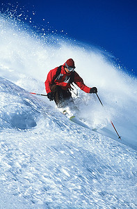 滑雪摄影照片_男子在山坡上滑雪