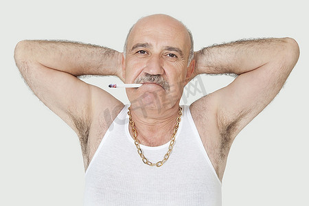 香烟png摄影照片_穿着背心的老年男子在灰色背景下吸烟的肖像