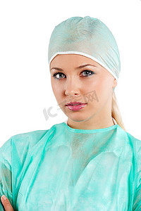 年轻的美容护士穿着绿色手术服，戴着手术帽