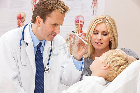 一个男医生检查一个生病的男孩孩子与他的母亲在手术或医院