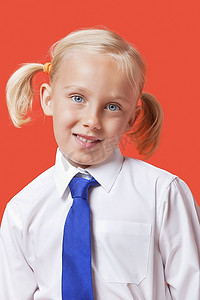校服女孩摄影照片_画象一个可爱的年轻女孩在蓝色背景的校服
