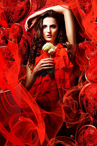 美丽火辣的黑发女子在恋爱中穿着红色连衣裙环绕着布料